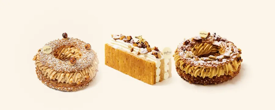 Lenôtre hazelnut Paris-Brest, peanut millefeuille and peanut Paris-Brest side by side on a cream background
